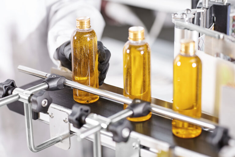 bottles of shampoo being filled on a conveyor belt